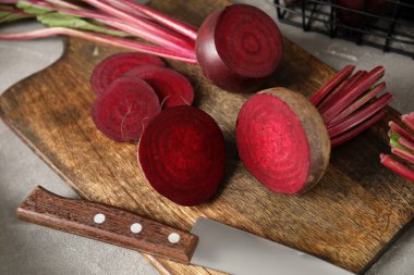 Taze pancar kökü ve gri masada bıçak ile kesme tahtası.