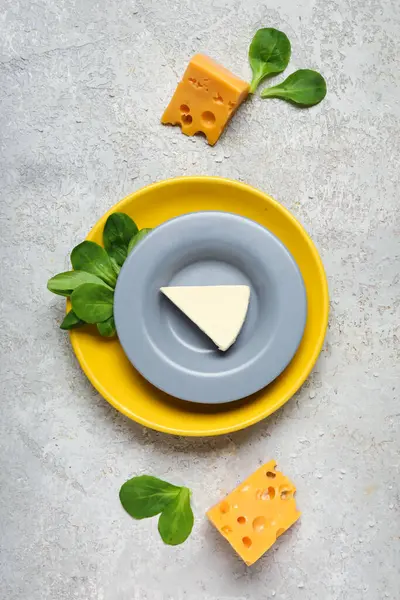 Gri arka planda lezzetli işlenmiş ve İsviçre peyniri olan tabaklar