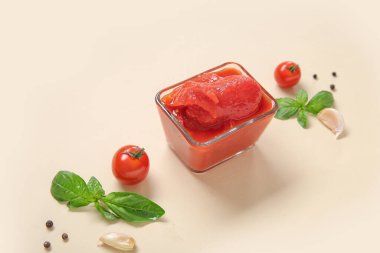 Renkli arkaplanda bir kase konserve domates ve baharatla kompozisyon