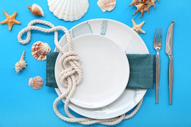 Mavi arka planda deniz dekoruyla servis edilen güzel bir masa.