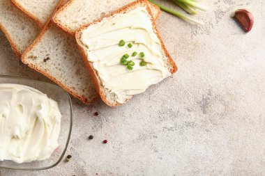 Beyaz arka planda tereyağlı ve yeşil soğanlı lezzetli tostlar.