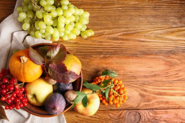 Farklı taze meyveler, balkabağı ve böğürtlenlerle dolu bir kase.