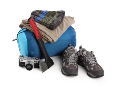 Set of camping equipment with sleeping bag, hatchet and photo camera on white background