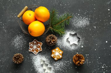 Lezzetli portakallı sepet ve siyah arka planda tatlı Noel kurabiyeleri.
