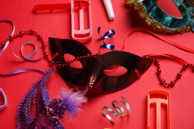Kırmızı arkaplanda dekoru olan karnaval maskeleri