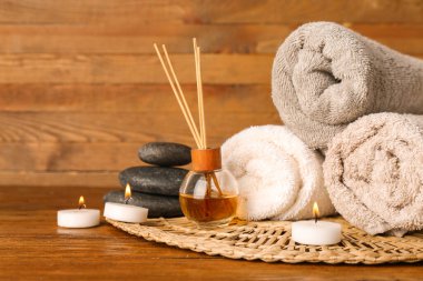 Ahşap masada yanan mumlarla spa kompozisyonu
