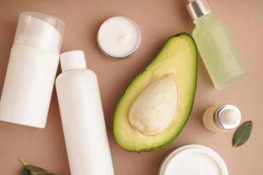 Renk arkaplanına farklı kozmetik ürünleri ve avokado seti