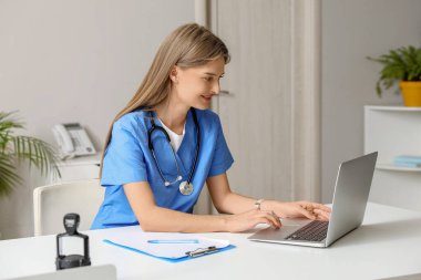 Ofiste dizüstü bilgisayarla çalışan kadın doktor.