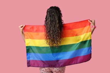 Pembe arka planda gökkuşağı bayrağı olan Afro-Amerikalı bir kadın. LGBT kavramı
