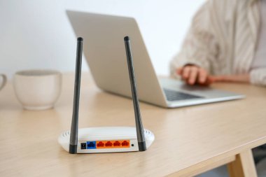 Modern wi-fi router masadaki kadının odada laptop kullanması, yakın çekim