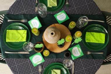 Yanan mumlar ve yoncalarla servis edilen şenlik masası, üst manzara. Aziz Patrick Günü kutlaması