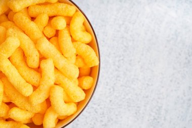 Hafif arka planda lezzetli tuzlu mısır çubukları olan kase, yakın plan.