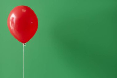 Yeşil zemin üzerinde kırmızı yüzen balon