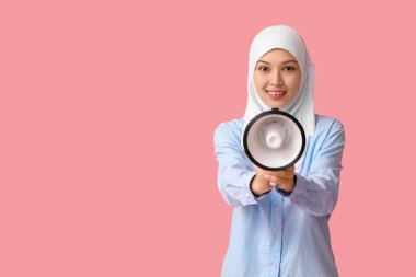 Pembe arka planda megafonu olan genç Asyalı Müslüman kadın. Ulusal Duyulma Günü