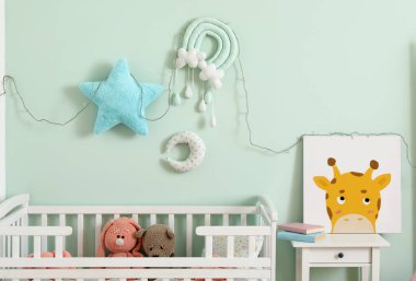 Bebek beşiği, resim ve oyuncaklarla dolu bir çocuk odası.