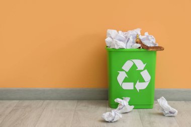 Bej duvarın yanında kağıt olan geri dönüşüm kutusu. Geri dönüşüm kavramı