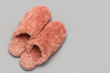 Gri arka planda bir çift kırmızı yumuşak terlik. Üst görünüm