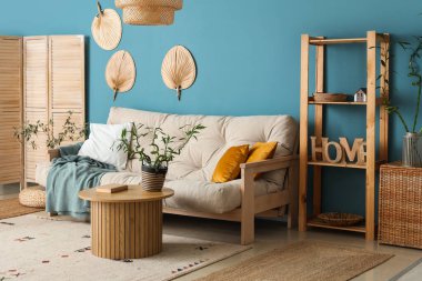 Kahve masası ve kanepenin üzerinde bambu sapları olan şık bir oturma odası.