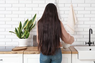 Mutfakta çaydanlığı olan genç ve güzel bir kadın.