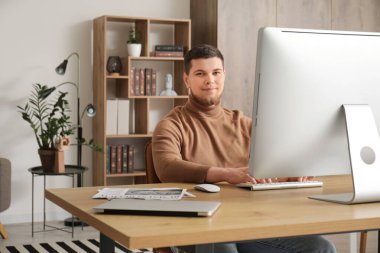 Ofisteki bilgisayarı kullanan genç sakallı adam.