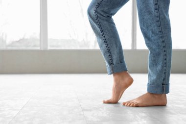 Genç bir kadın yeni lamine döşeme üzerinde yürüyor.