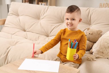 Evde keçeli kalemleri olan sevimli küçük bir çocuk.