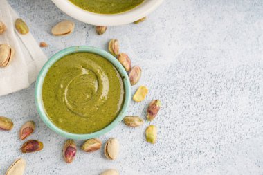 Beyaz grunge arka planda lezzetli şam fıstığı ezmeli kase