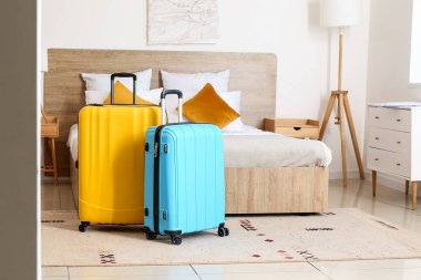 Yatağın yanında bavulları olan, köşeden manzaralı modern bir otel odası.