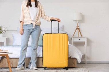 Bavullu kadın otel odasında.