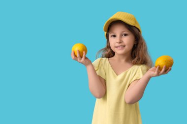 Mavi arka planda limonları olan şirin küçük bir kız.