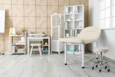 Kanepesi, doktor çalışma yeri ve raf üniteleri olan bir hastane.