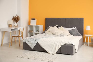 Yatağı, yatağı ve çalışma yeri olan modern bir yatak odası.