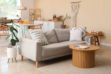 Gri kanepesi ve masası olan şık bir mutfak.