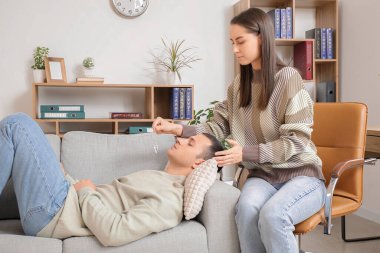 Ofiste sarkacı hipnotize eden adam olan kadın psikolog.