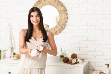 Banyoda hindistan cevizi yağlı güzel bir kadın. Kozmetoloji kavramı