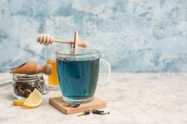 Mavi grunge arkaplanda bir fincan kelebek çiçeği çayı.