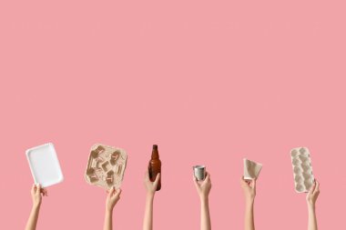 Pembe arka planda farklı çöpleri tutan kadın eller. Geri dönüşüm kavramı