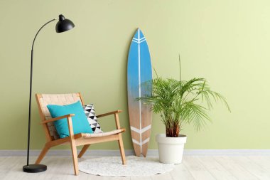 Konforlu koltuğu, lambası, çiçek ve sörf tahtasıyla modern oturma odasının içi