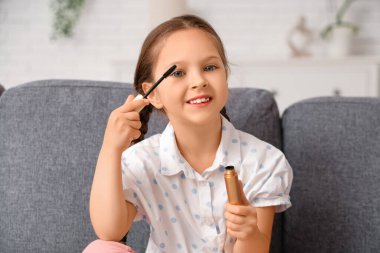 Oturma odasında maskarası olan tatlı küçük kız.