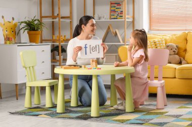 Ofiste F harfini telaffuz eden küçük tatlı bir kızı olan bir kadın konuşma terapisti.