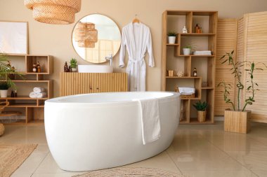 Modern banyonun içinde ev bitkileri ve bornoz asılı.