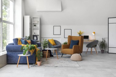 Oturma odasında rahat bir kanepe, koltuklar ve sehpa.