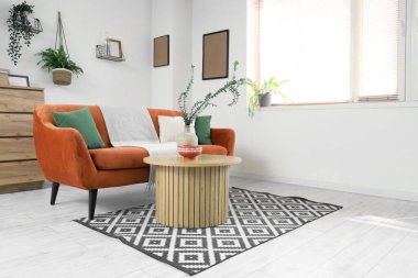 Rahat kanepe, çekmece sandığı ve oturma odasındaki sehpanın üzerinde okaliptüs dalları.