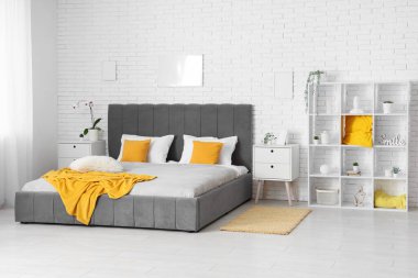 Rahat bir yatak, raf üniteleri ve yatak odasındaki komodinlerin yanında. Bulanık görünüm