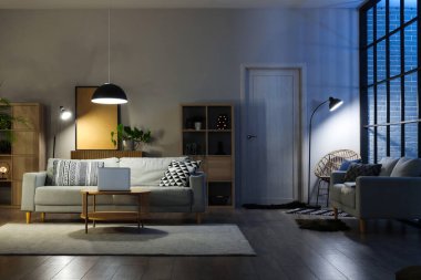 Rahat kanepeleri, masası ve parlak lambaları olan oturma odasının içinde.