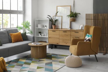 Oturma odasının içinde şık bir kanepe, rahat bir koltuk ve kahve masası var.