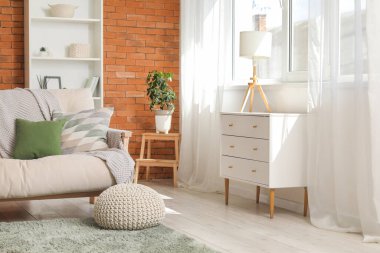 Rahat kanepe, puf ve sandık dolusu çekmece ve oturma odasının içinde lamba.