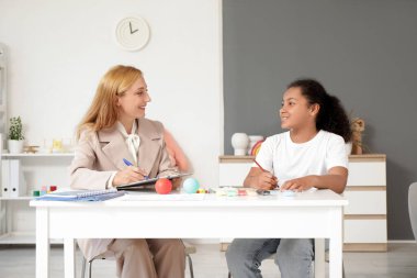 Ofiste Afro-Amerikalı bir kızla çalışan kadın psikolog.