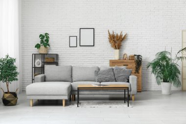 Rahat kanepesi, sehpası ve saksısı olan şık bir oturma odası.