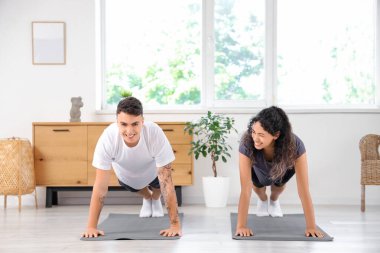 Genç çift evde pilates yapıyor.